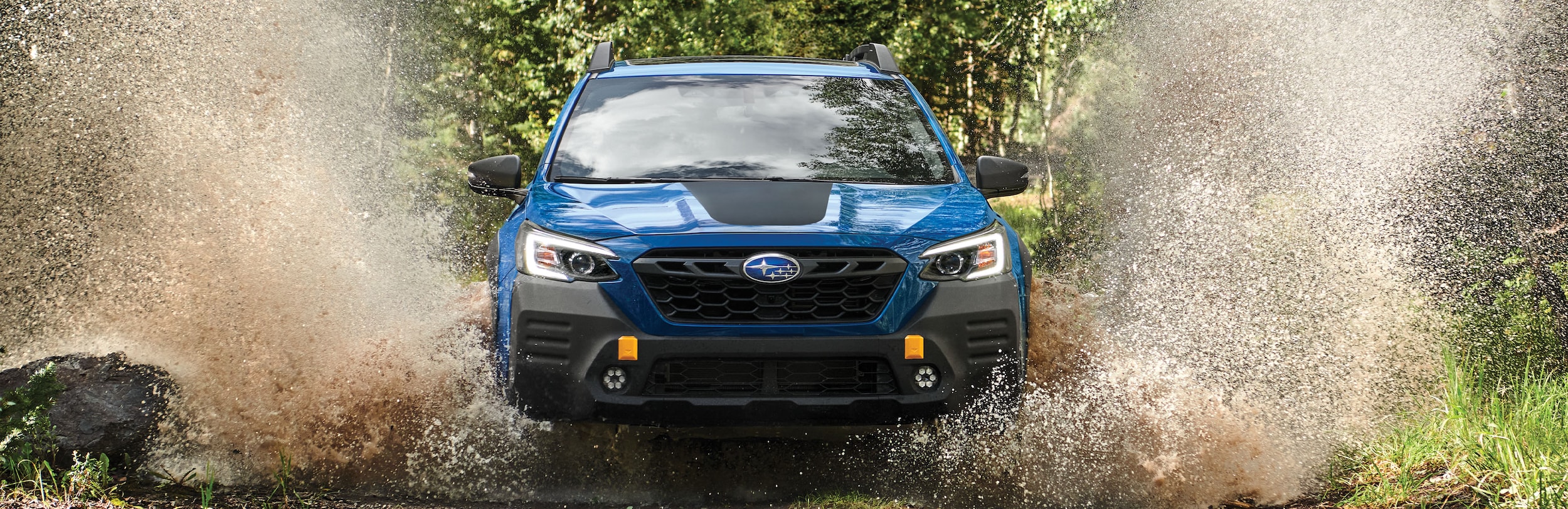 A 2023 Outback Wilderness driving on a muddy trail.