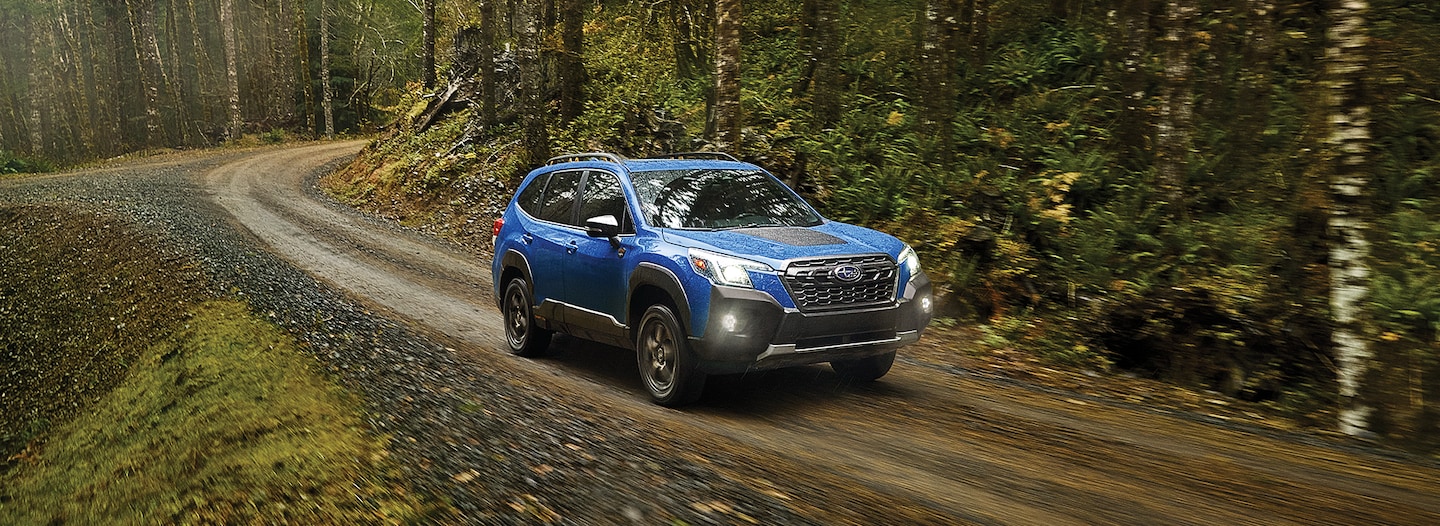 A 2023 Forester Wilderness driving through the woods