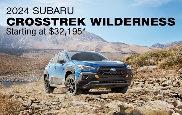 2024 Subaru vehicle parked on desert gravel with mountains in background.