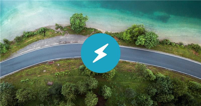  A white lightning bolt icon on a light blue circle, overlaid on an aerial view forest with a dirt path. 