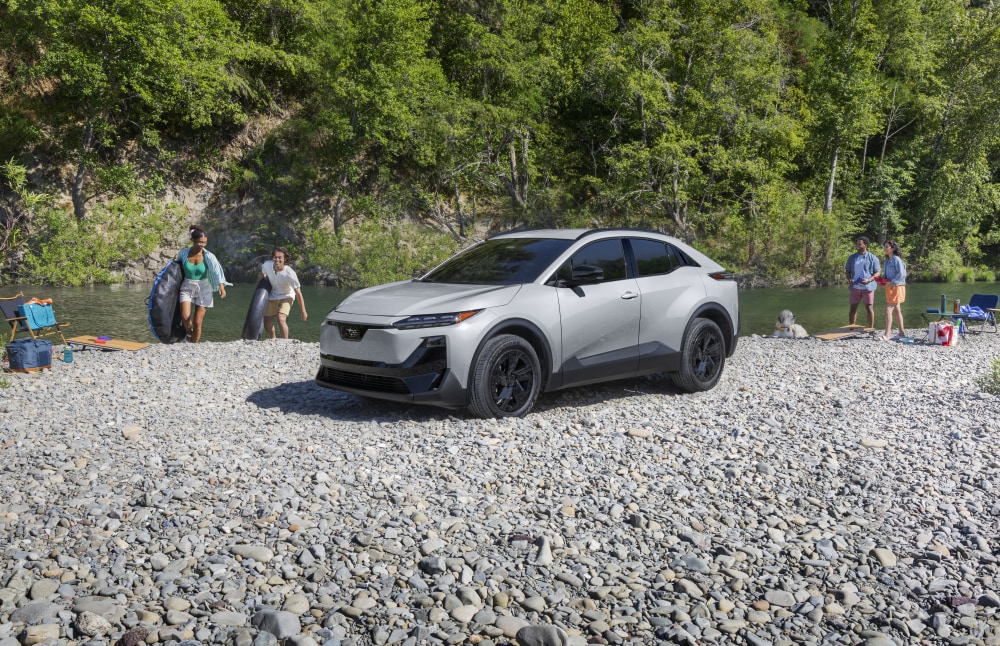 A static image of Uncharted Sport in Metropolis Gray Metallic parked on a rocky bank of a river. 