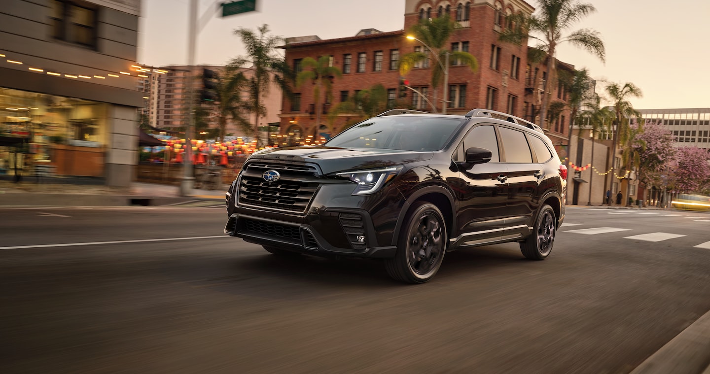 Black 2026 Subaru Ascent drives through a downtown neighborhood.