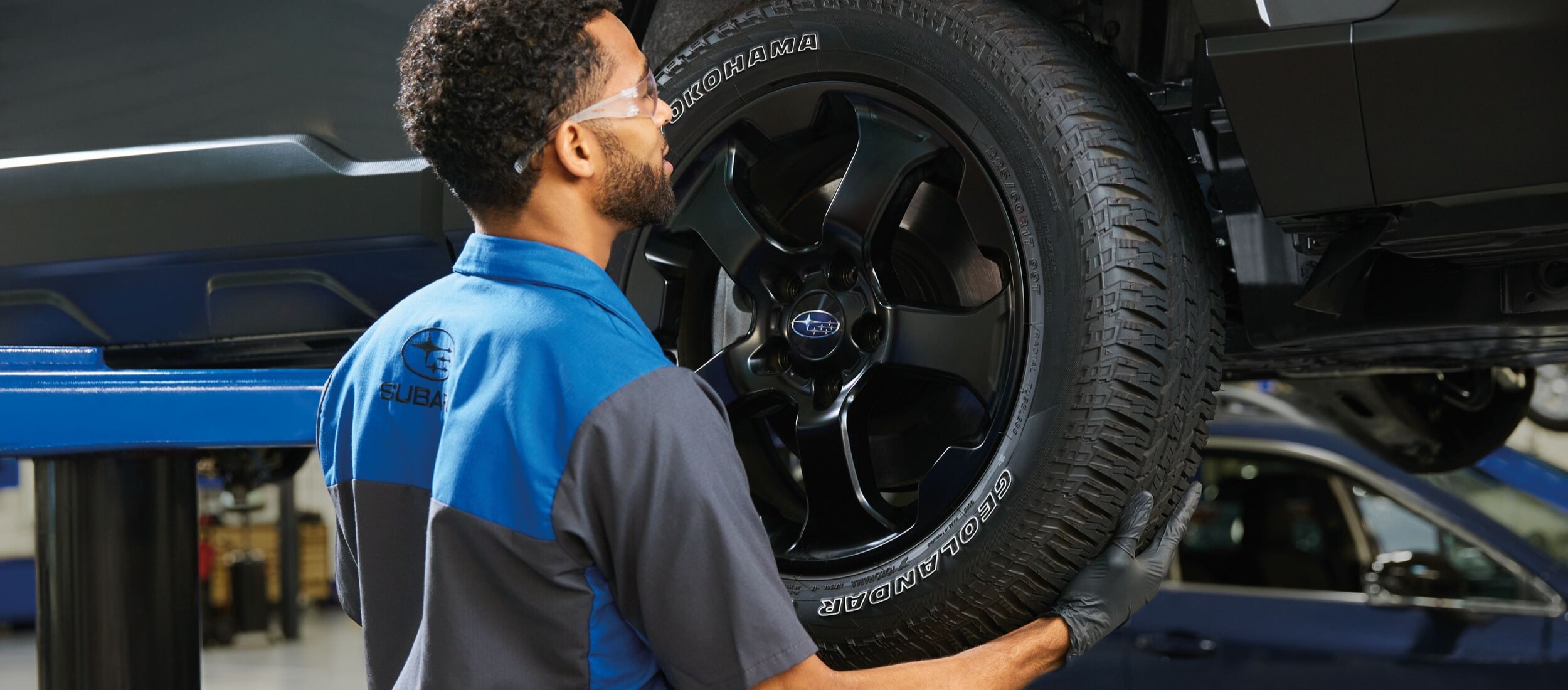  A Subaru service technician checking tires.