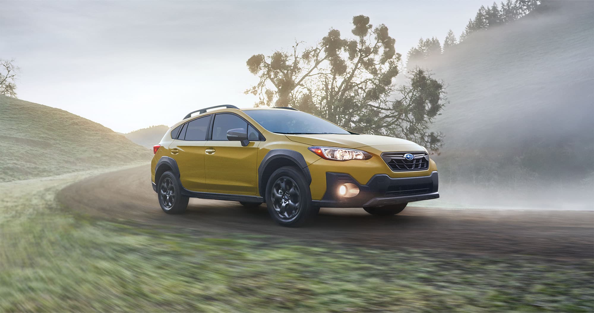 A 2023 Crosstrek driving on a dirt road.