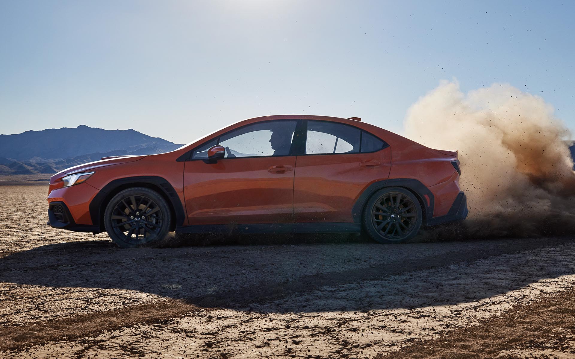 The 2022 Subaru kicking up dirt while driving on a desert road.  