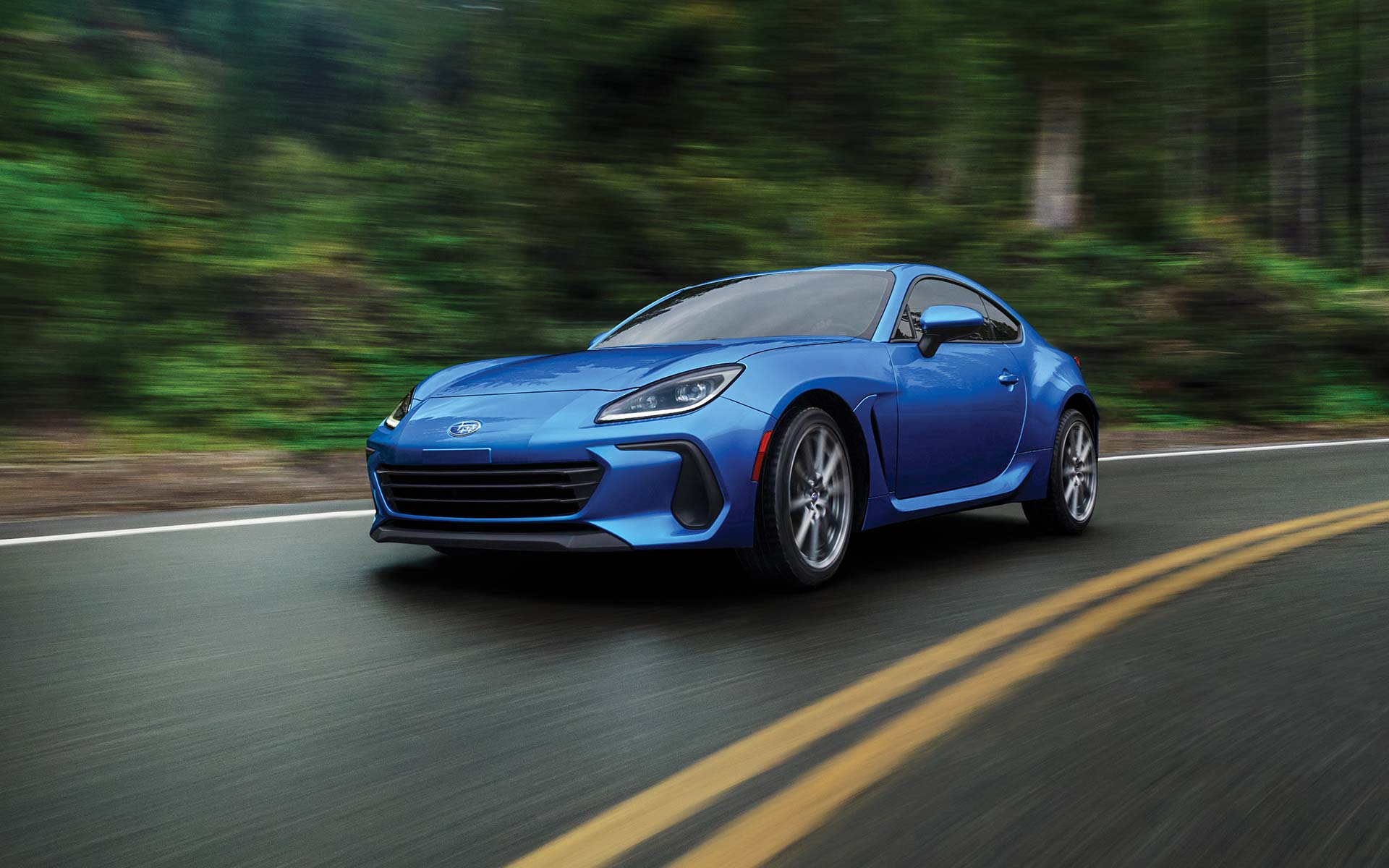 The 2022 Subaru BRZ Limited shown in WR Blue Pearl driving down forest highway. 