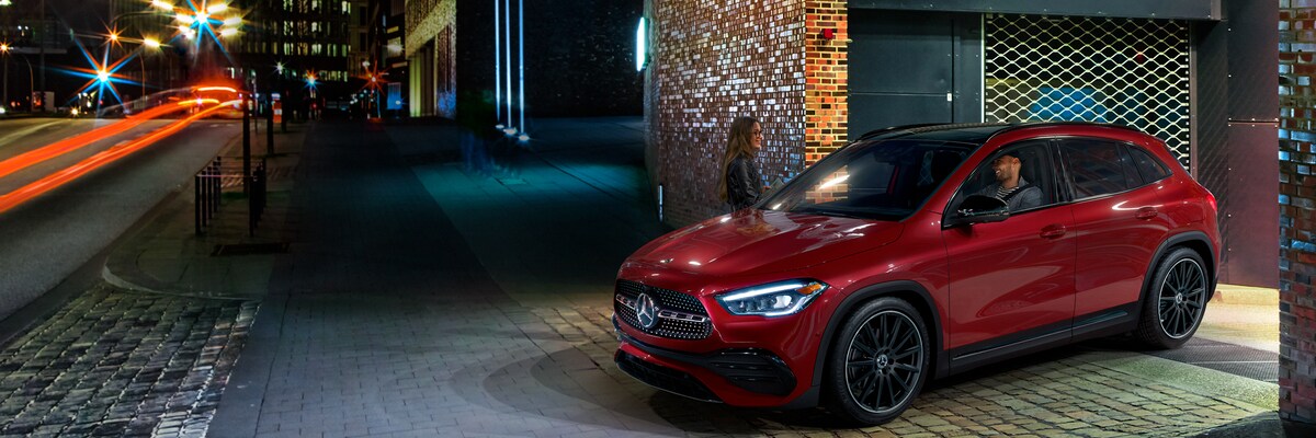 Red Mercedes-Benz GLA pulling onto a city street