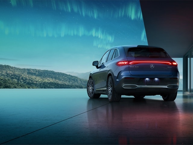 EQE SUV parked beside a modern house at night