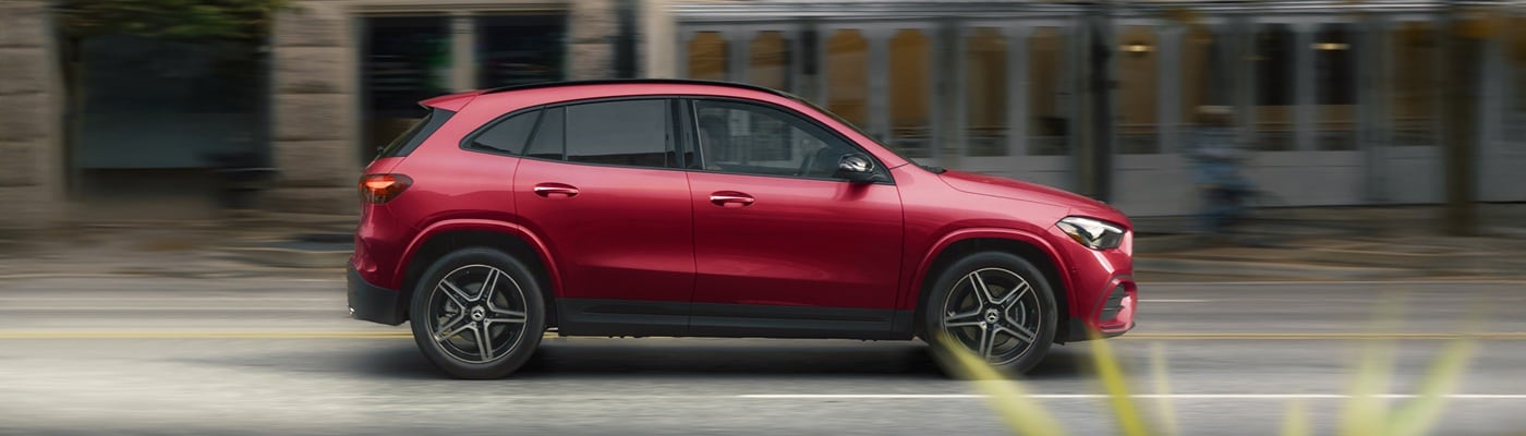 Red Mercedes-Benz AMG GLA 35 driving on a city street