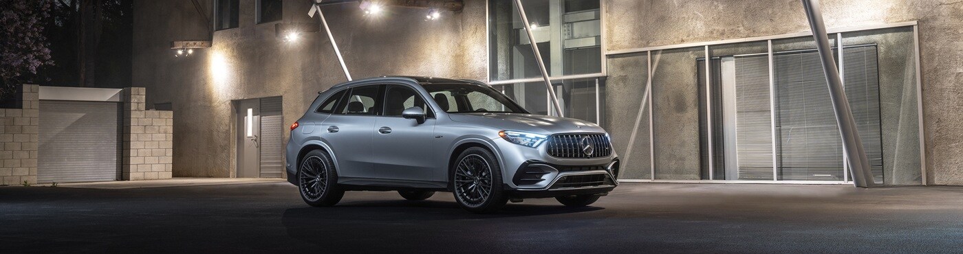 Mercedes-Benz AMG® GLC Silver Mercedes-Benz AMG GLC parked in front of a building