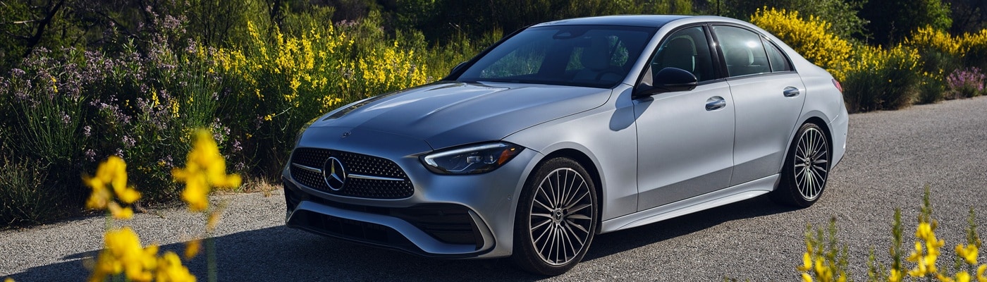 White Mercedes-Benz AMG C-Class parked in a flowering meadow