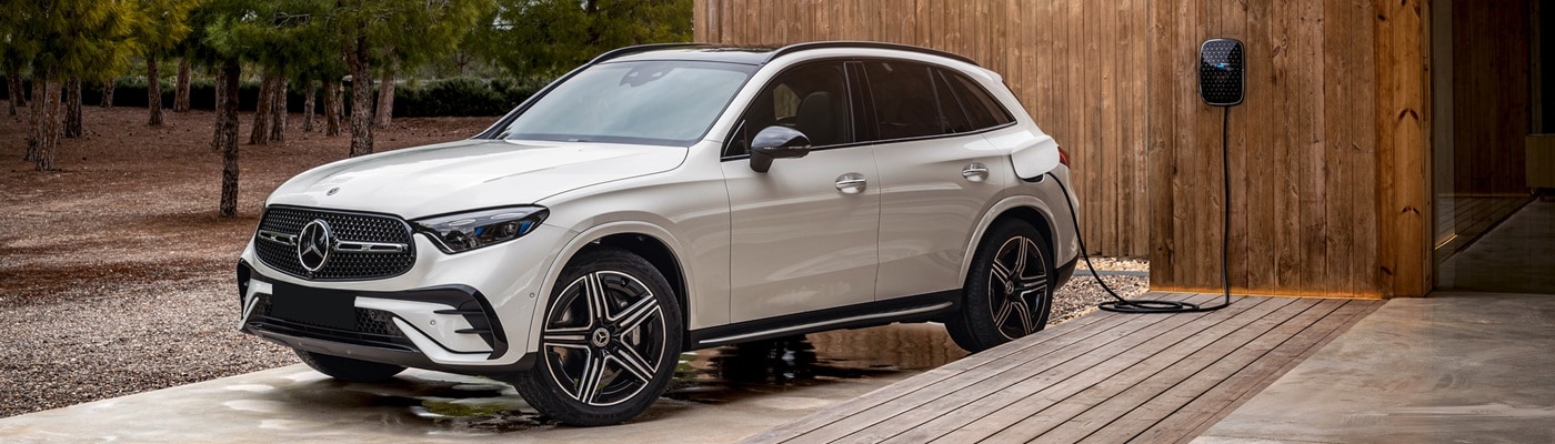 White Mercedes-Benz AMG GLC plugged in at a modern home