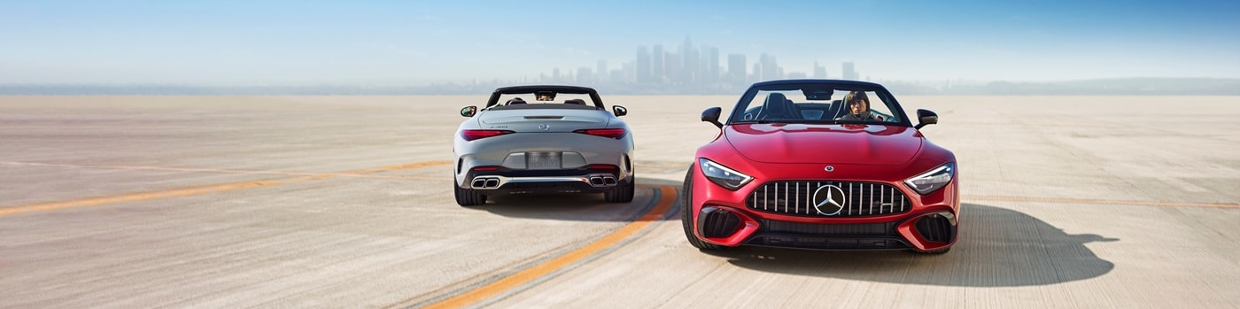 Two Mercedes-Benz SL Models parked in front of a city