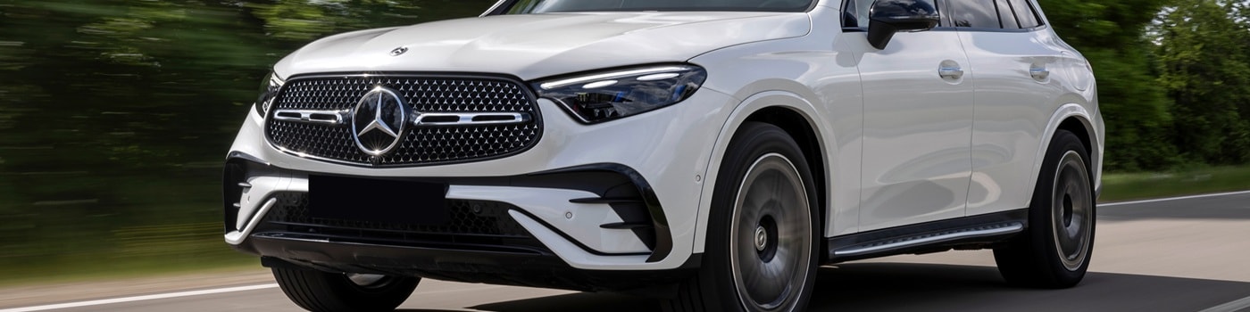 Mercedes-Benz AMG GLC SUV White Mercedes-Benz AMG GLC driving on a road in the forest