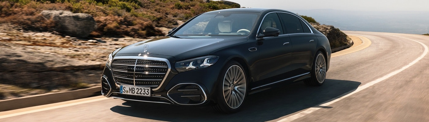 Black Mercedes-Benz S-Class driving on a sunny road