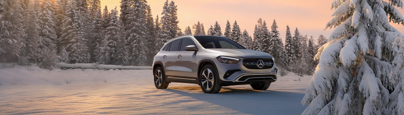 Silver Mercedes-Benz GLA SUV parked in a snowy forest