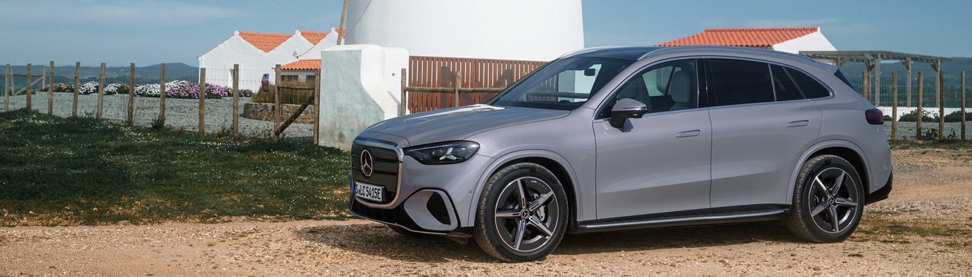 Grey Mercedes-Benz GLC EV SUV parked beside a windmill