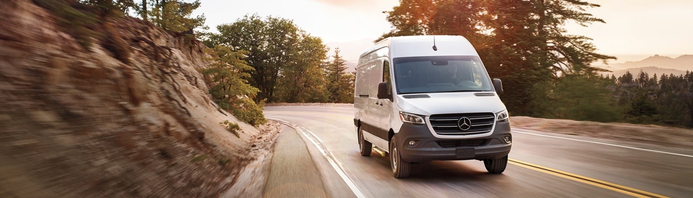 Mercedes-Benz Sprinter Cargo van driving on a road at dusk