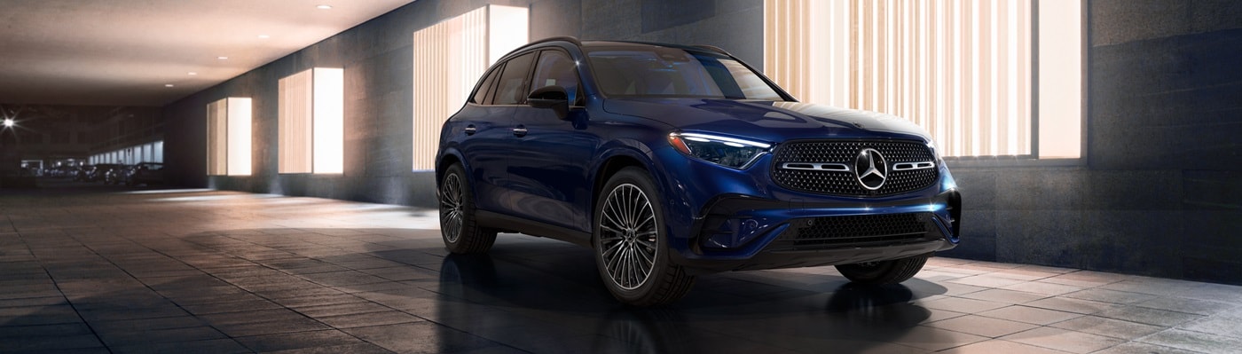 Blue Mercedes-Benz GLC SUV parked by a building in a city
