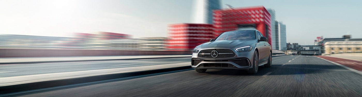 Grey Mercedes-Benz C-Class Sedan driving on a city street