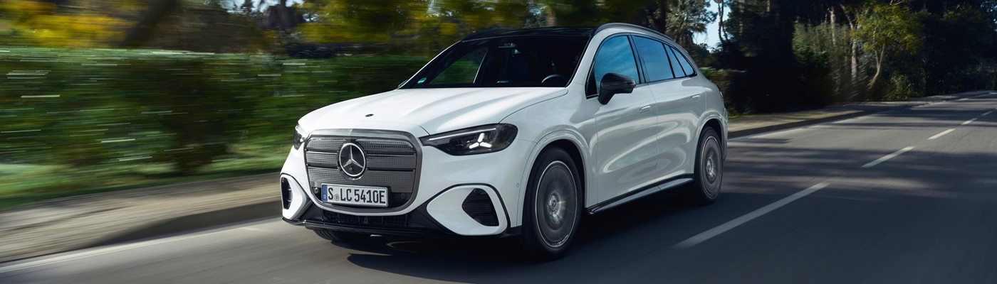 White Mercedes-Benz GLC EV SUV driving on a sunny road