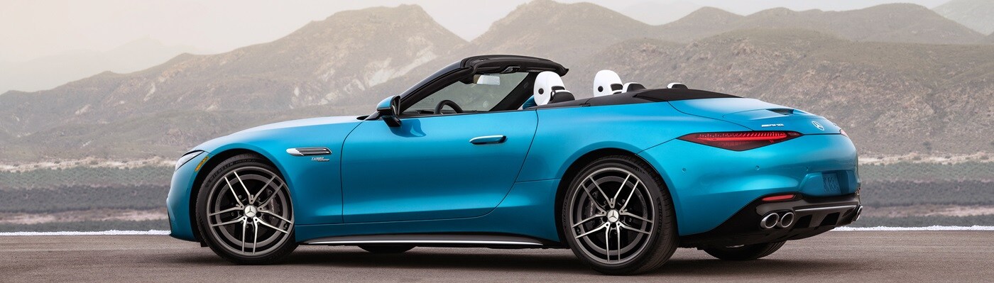 Blue Mercedes-Benz SL models parked in front of a mountainscape