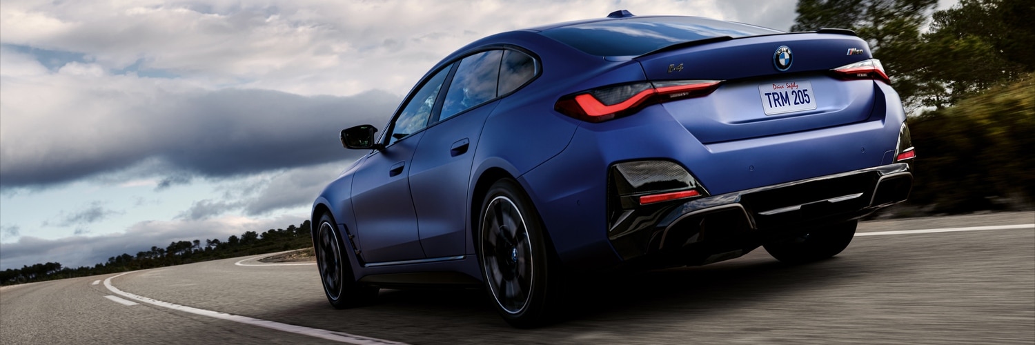 2024 BMW i4 blue 2023 BMW i4 driving on a curved road