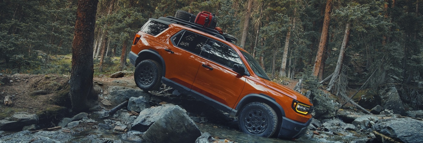 Honda Passport TrailSport Elite Orange Passport TrailSport Elite fording a river in a forest