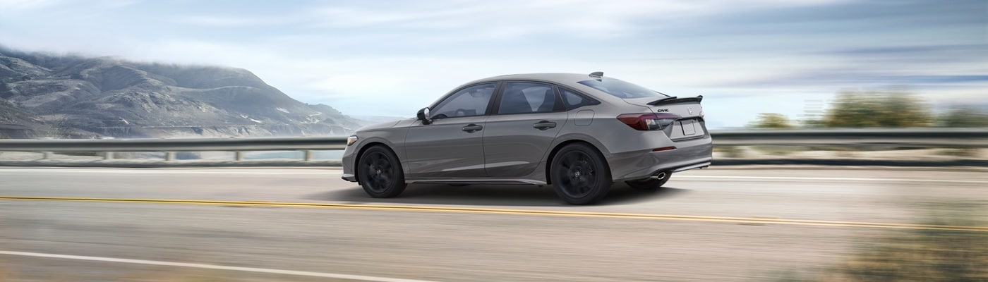 Honda Civic Si Grey Honda Civic Si driving on a road near the coast