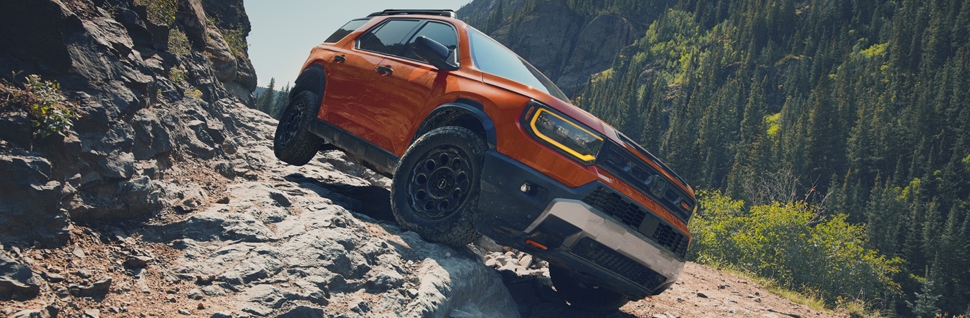 Orange Passport TrailSport Elite performing a rock crawl