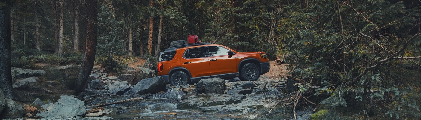 Honda Passport TrailSport Elite Orange Passport TrailSport Elite fording a river in the forest