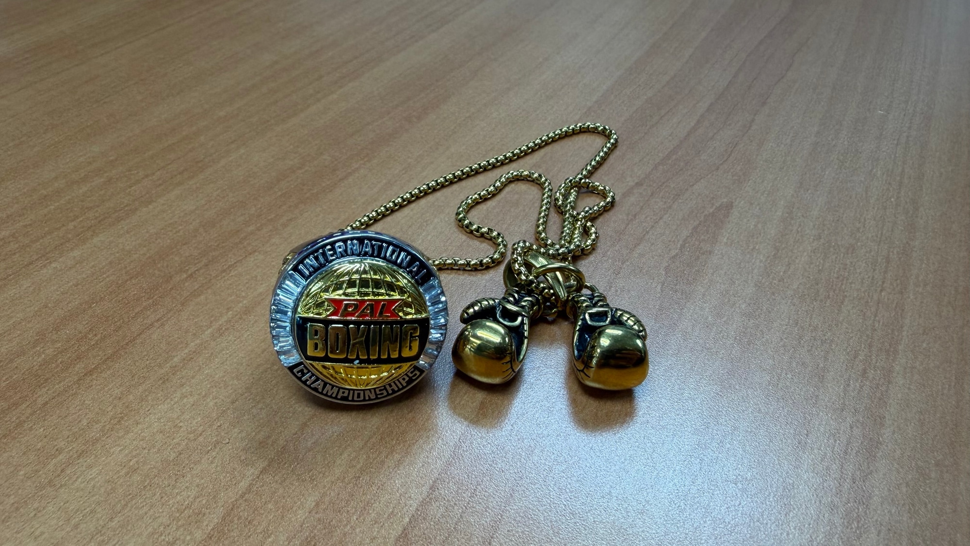 PAL Boxing International Championship Necklace sitting on a table
