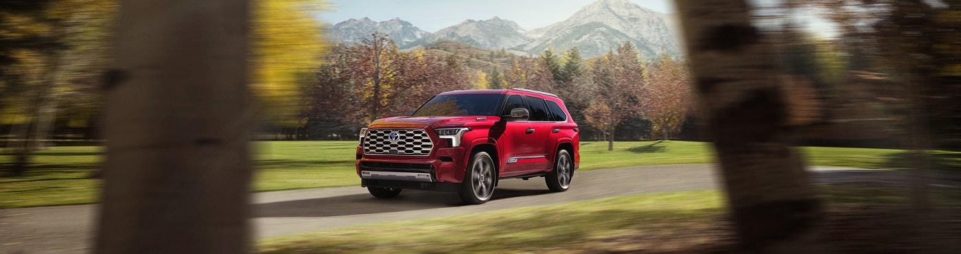 Red Toyota Sequoia Capstone driving on a road in the fall
