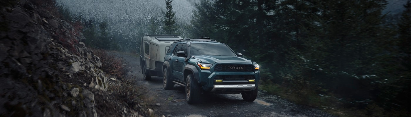 Blue Toyota 4Runner Trailhunter towing a camper in the mountains