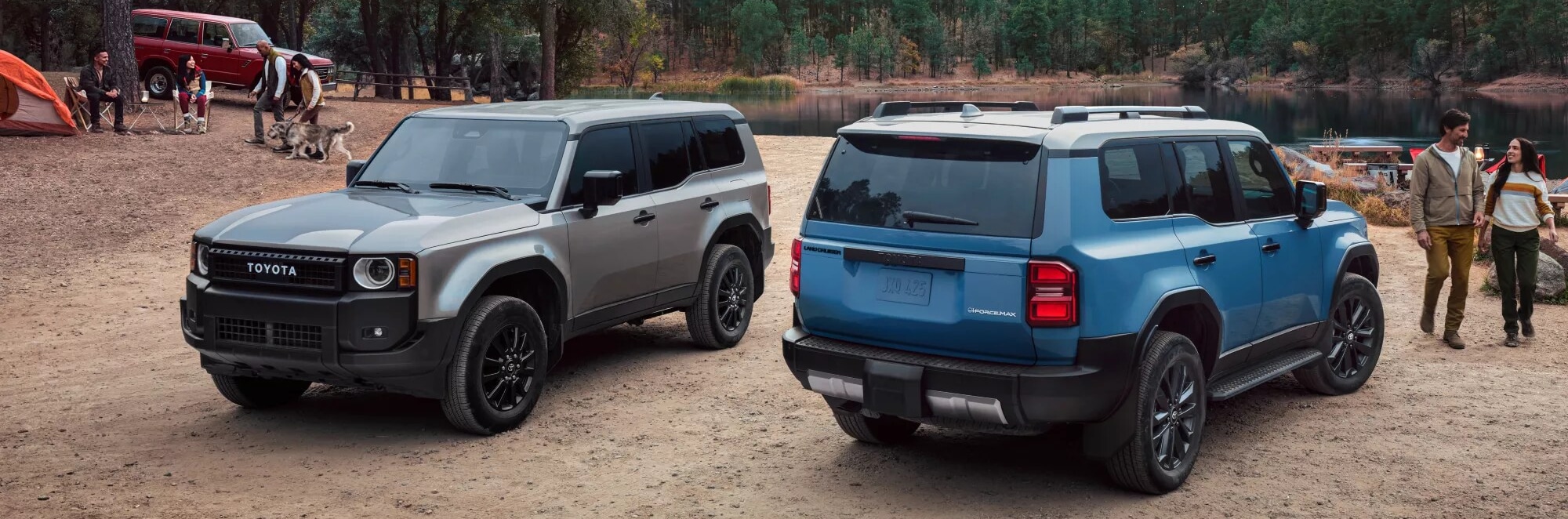 Two Toyota Land Cruiser SUVs parked by a lake