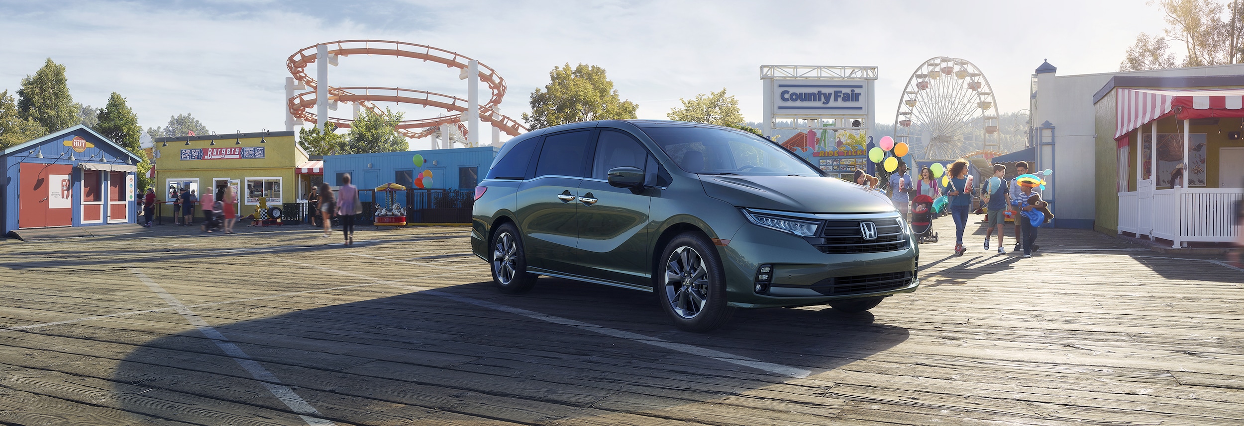 Green Honda Odyssey Elite parked on a board walk