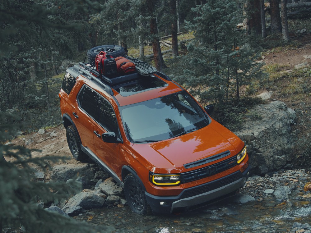 Orange Honda Passport Trailsport driving in a forest