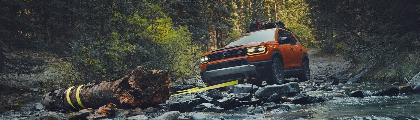 Honda Passport TrailSport Elite Orange Passport TrailSport Elite winching a log in a river