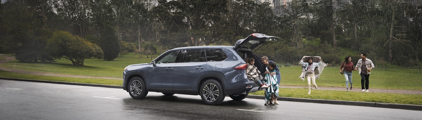 Blue Toyota Grand Highlander Hybrid in the rain