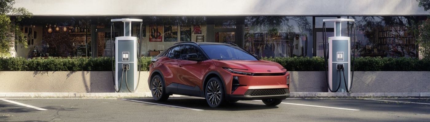 2026 Toyota C-HR with Tandoori paint and Midnight Black Metallic roof driving at EV charger.jpg