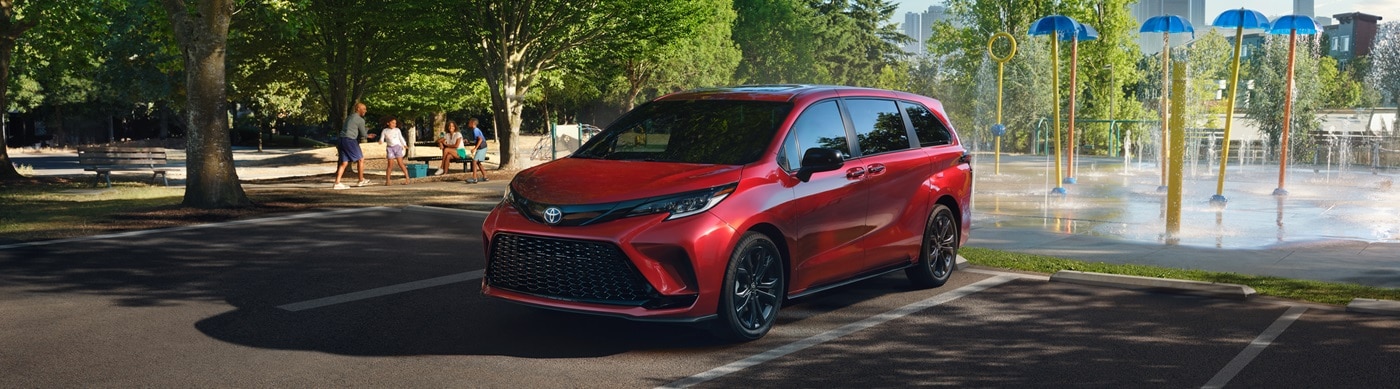 Red Toyota Sienna XSE parked in a city park