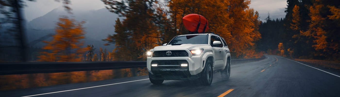 Grey Toyota 4Runner TRD Off Road driving on a rainy forest road