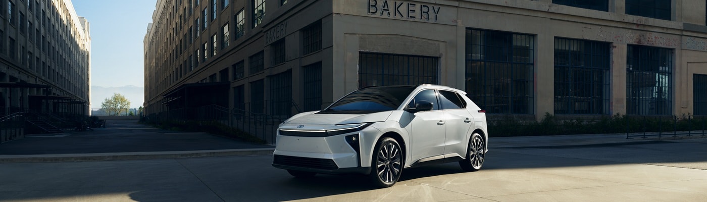 White Toyota bZ Limited parked in front of a bakery