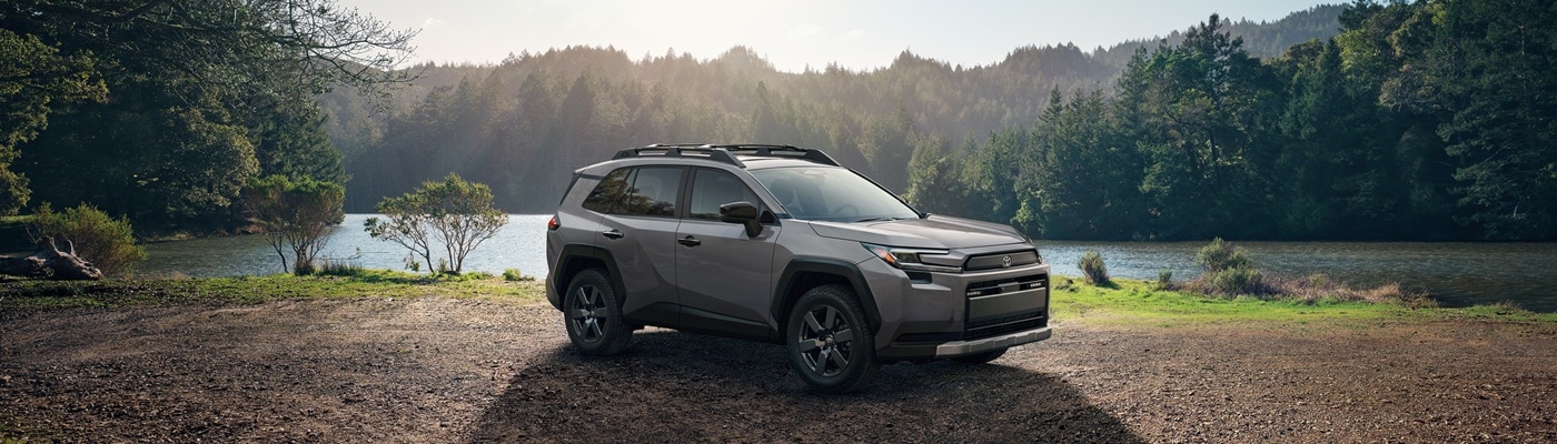 Tan Toyota RAV4 Woodland parked by a lake in the woods