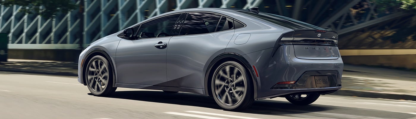 Grey Toyota Prius PHEV XSE Premium driving in a city