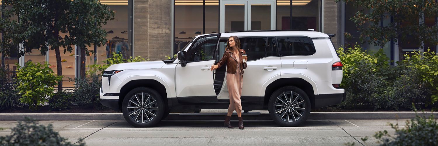 White Lexus GX 550 parked in front of a downtown building