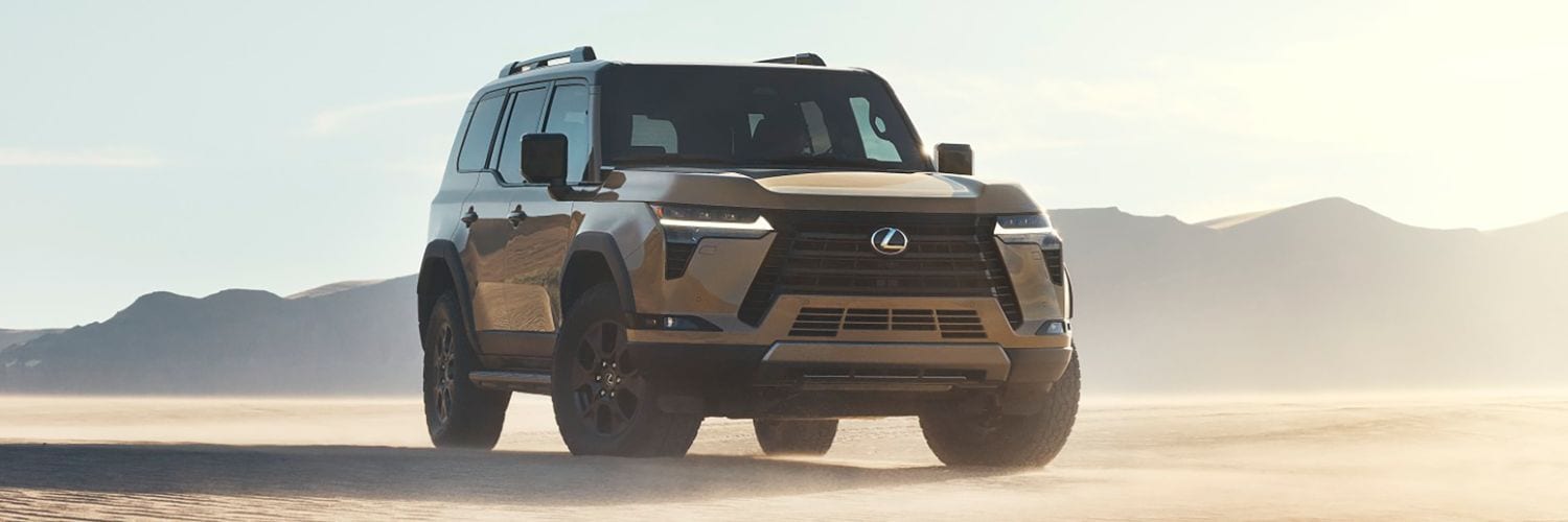 White Lexus GX 460 driving by a lake