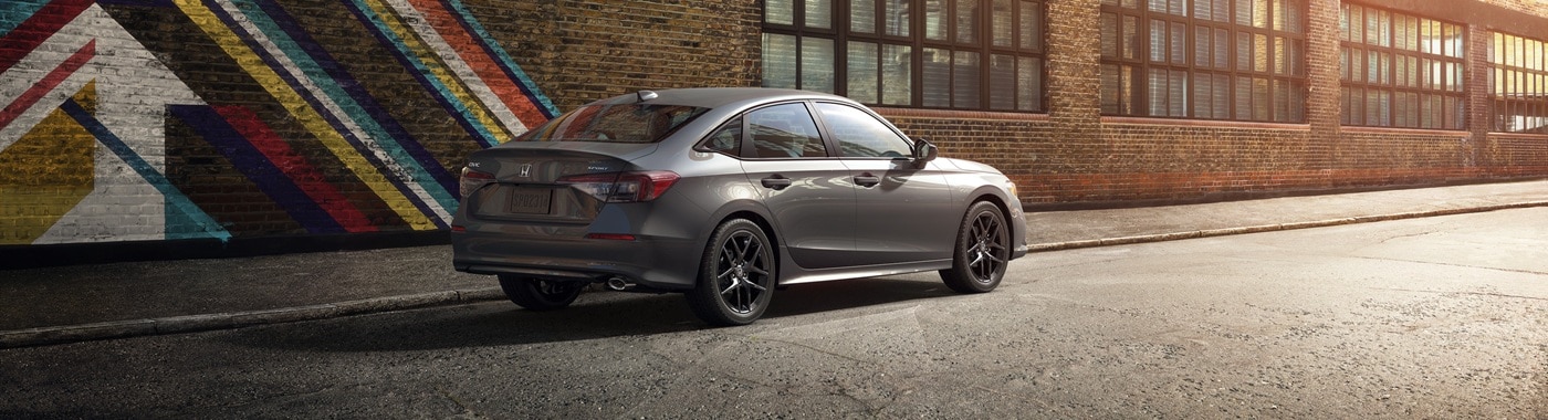 Grey Civic Sport parked in front of a brick wall