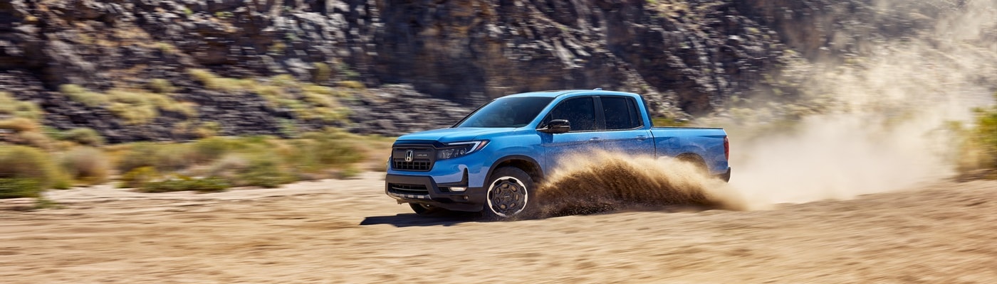 Blue Honda Ridgeline TrailSport driving thru the sand