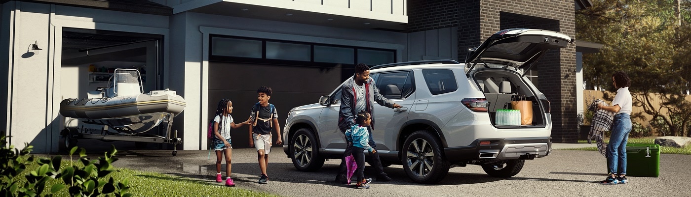 White Honda Pilot Elite in a suburban driveway